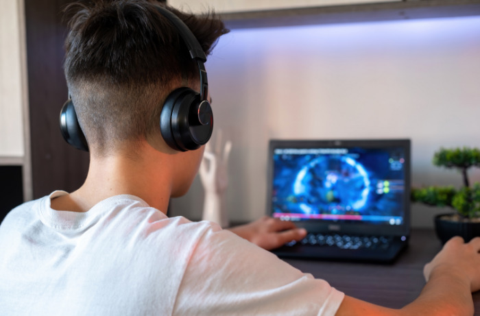 A boy playing game on his gaming laptop